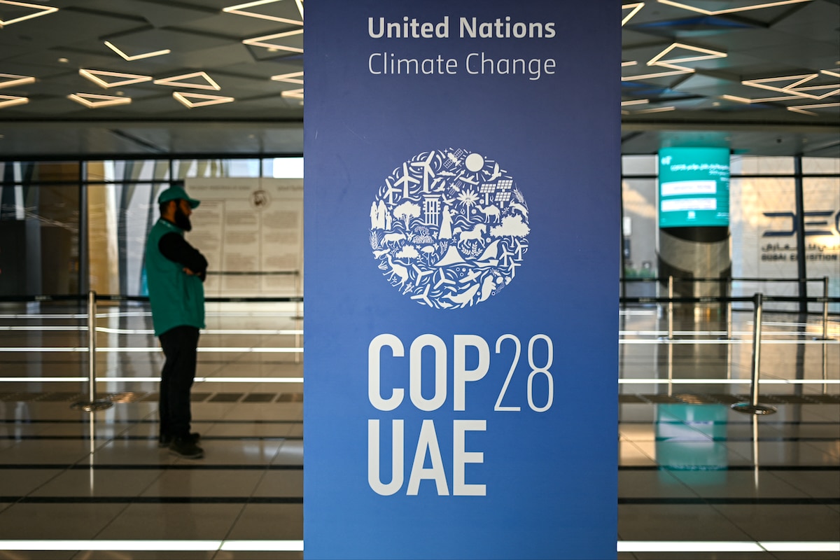 A man stands near a COP28 sign in a metro station in Dubai, United Arab Emirates ahead of the United Nations climate summit,